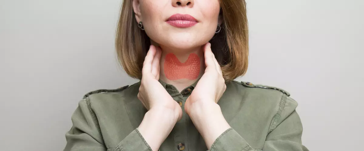 Kobieta dotykająca tarczycy