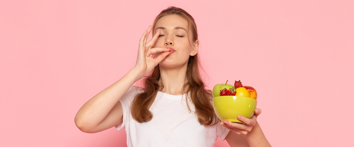 Uśmiechnięta nastolatka trzymająca miskę owoców