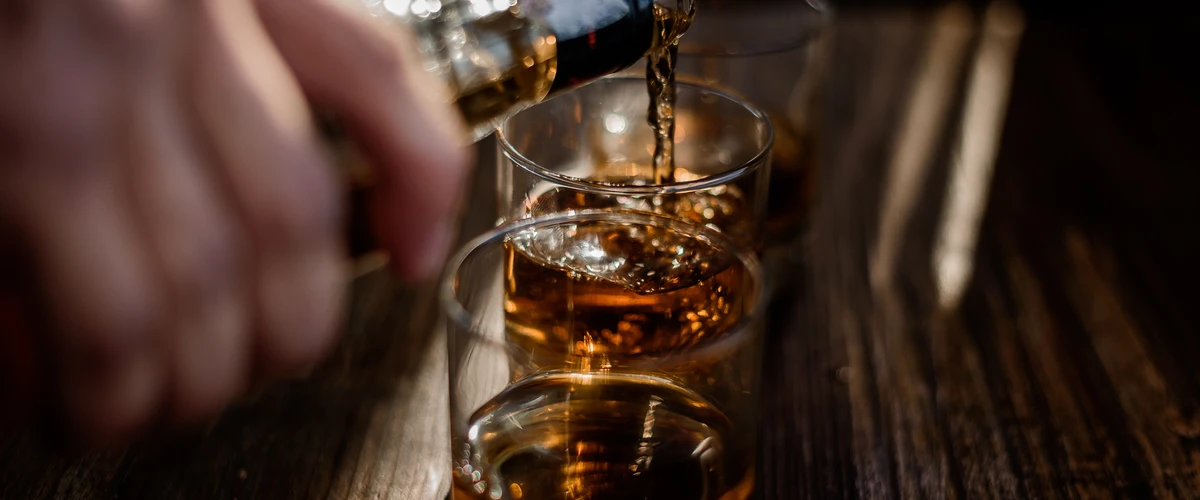 Mężczyzna nalewa alkohol do szklanki