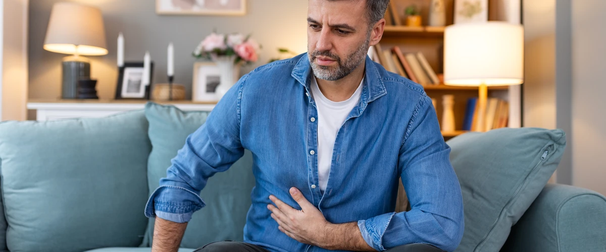 Mężczyzna trzymający się za brzuch