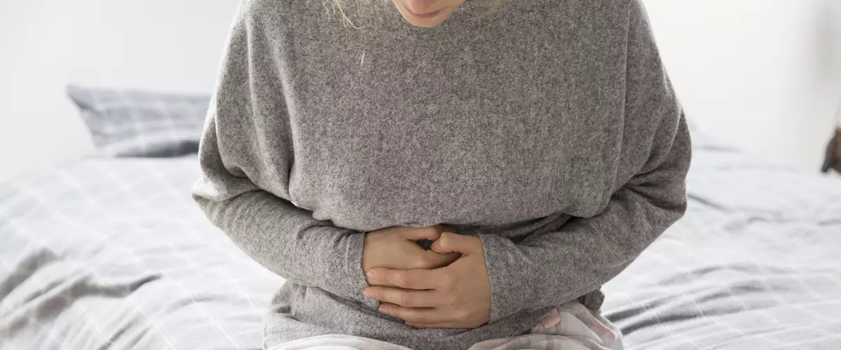 kobieta trzymająca sie za brzuch