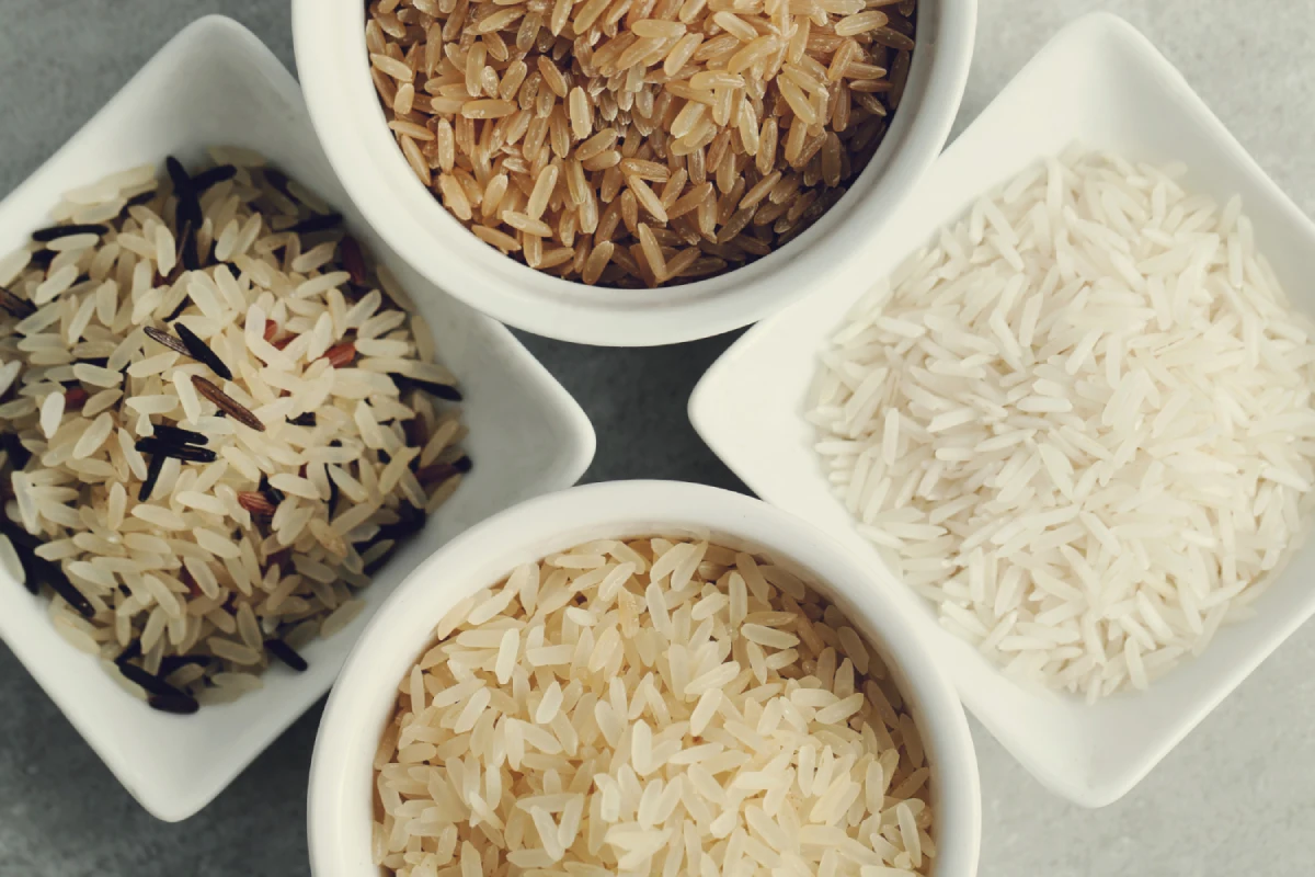 Cztery białe miski z różnym typem ryżu