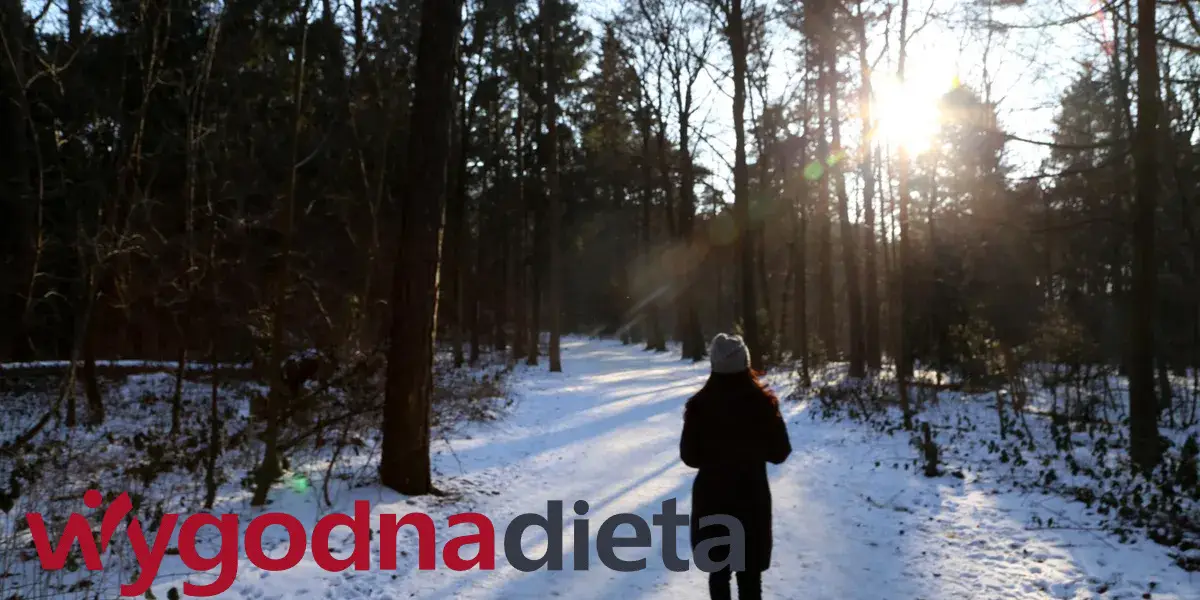 kobieta spacerująca w lesie zimą