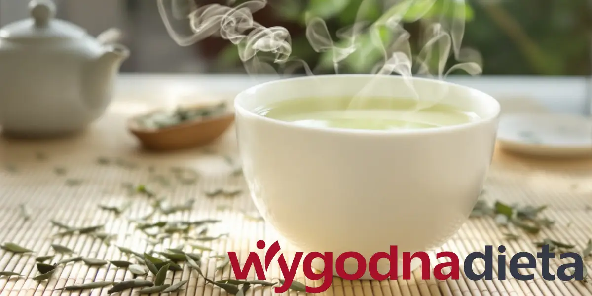 biała filiżanka z parującą zieloną herbatą