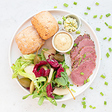 drugie śniadanie w sportowej diecie pudełkowej - pastrami z kolorowym pieprzem, sałatka z gruszką, kaparami i sosem musztardowym, bułeczka z ziołowym masełkiem