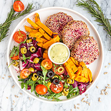 dinner in a vegetarian box diet - beetroot burgers in sesame coating, sweet potato fries, salad with cherry tomatoes, olives and honey dressing