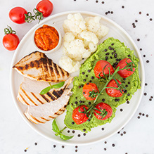 obiad w diecie pudełkowej bez glutenu - grillowany filet z kurczaka z pomidorkami cherry, purée z zielonego groszku, kalafior z belugą i dipem paprykowym